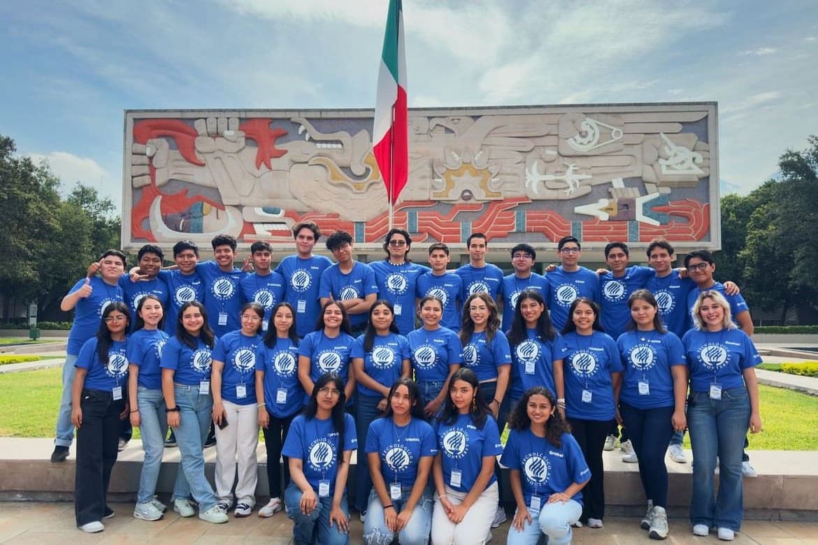 Foto de generación completa frente al mural del campus